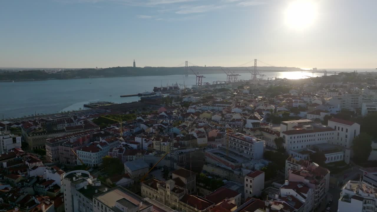 Drone shot of Lisbon with the bridge and the statue in the background.