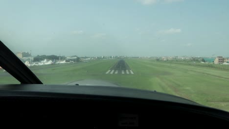 landing of propeller plane in nairobi kenya east africa during the day, handheld windshield front shot