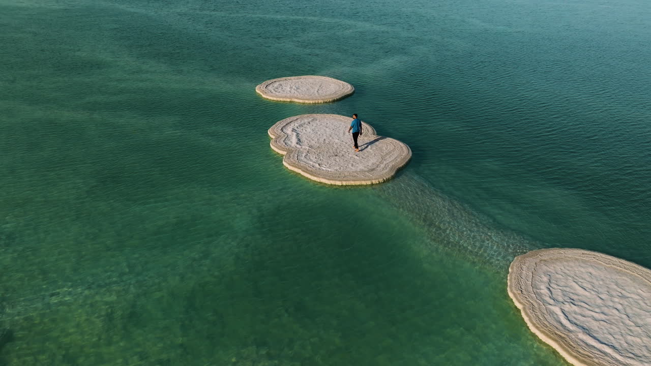 Luftaufnahme einer Person über Salzformationen am beeindruckenden Toten Meer in Israel.