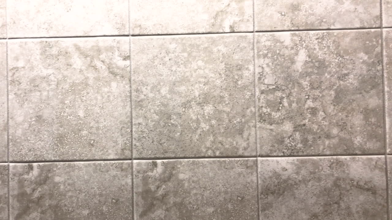 azulejos de la pared del baño en patrón lineal y forma cuadrada