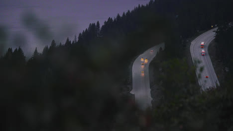 Long-shot-looking-down-at-a-freeway-where-cars-with-headlights-on-pass-in-slow-motion