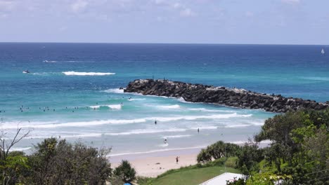 waves crashing on beach near rocky jetty