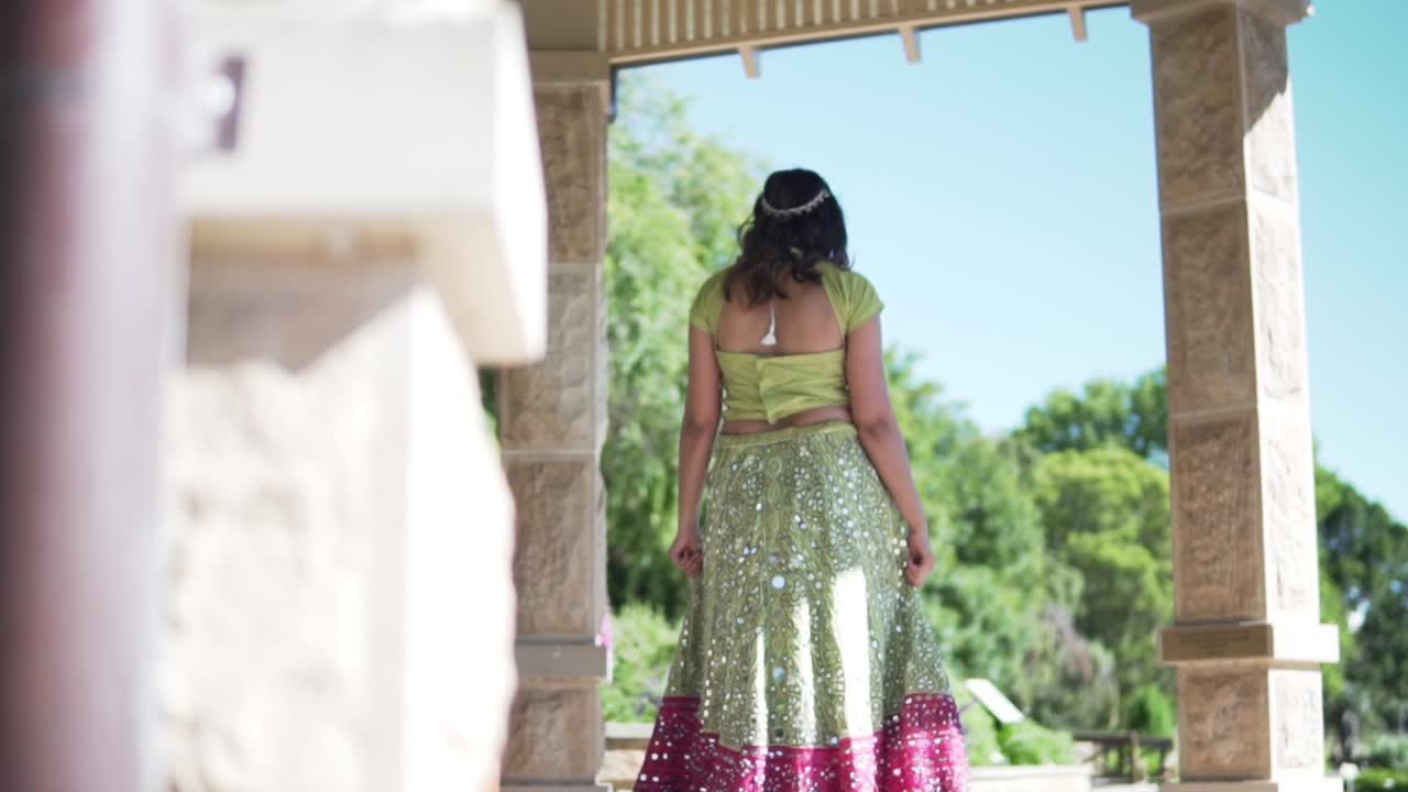 traseira de uma mulher sul-asiática em vestido tradicional indiano andando sob uma gôndola em sydney, austrália