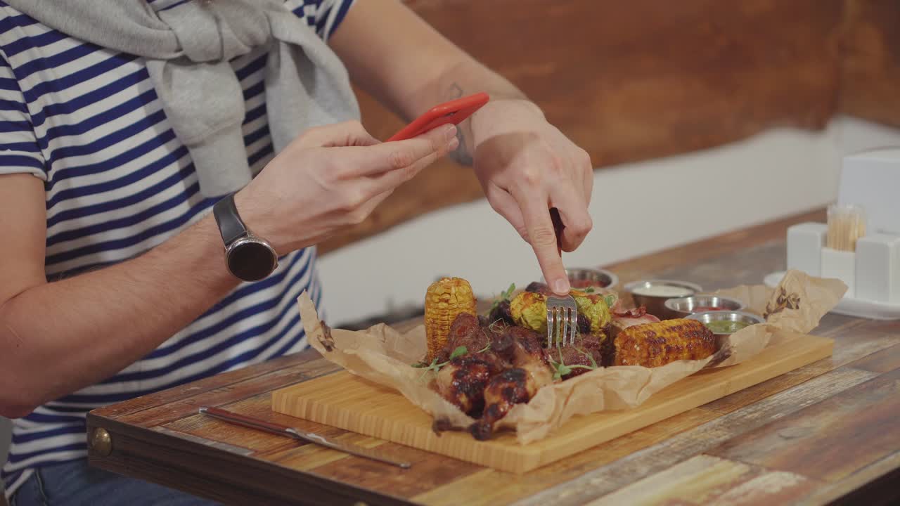 hombre tomando una foto de su comida en un restaurante