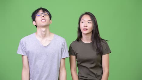 young asian couple looking disappointed together