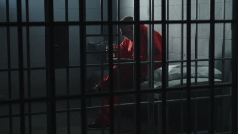 face close up of angry elderly prisoner standing behind metal bars          (stock footage)