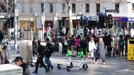 people walking and scooters on a busy street