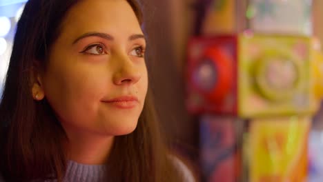 woman looking up at a brightly lit arcade game