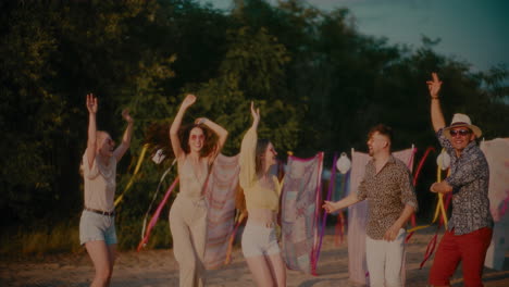 carefree men and women jumping during sunset party