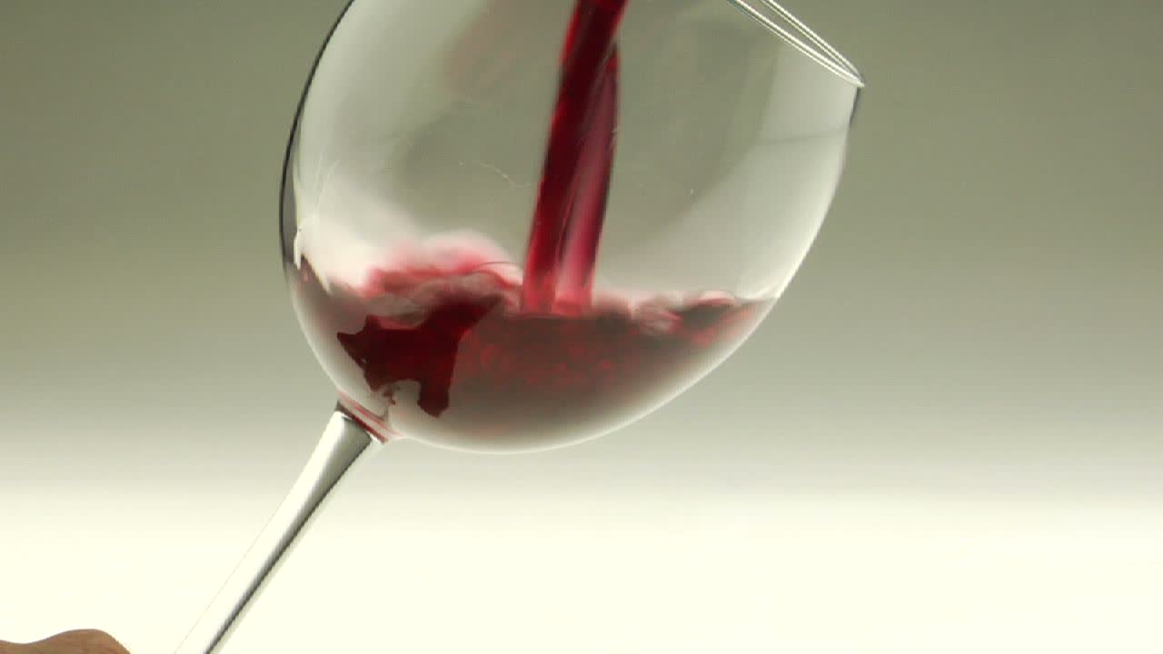 Vino rosso viene versato in un calice 1