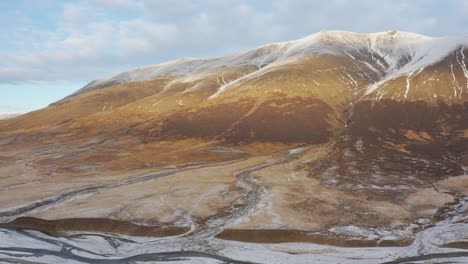 Ríos-Glaciares-Fluyen-Debajo-De-Fantásticas-Montañas-Nevadas-En-Los-Helados-Fiordos-Del-Oeste,-Islandia,-Antena-De-Drones,-Invierno-De-Reykjavik