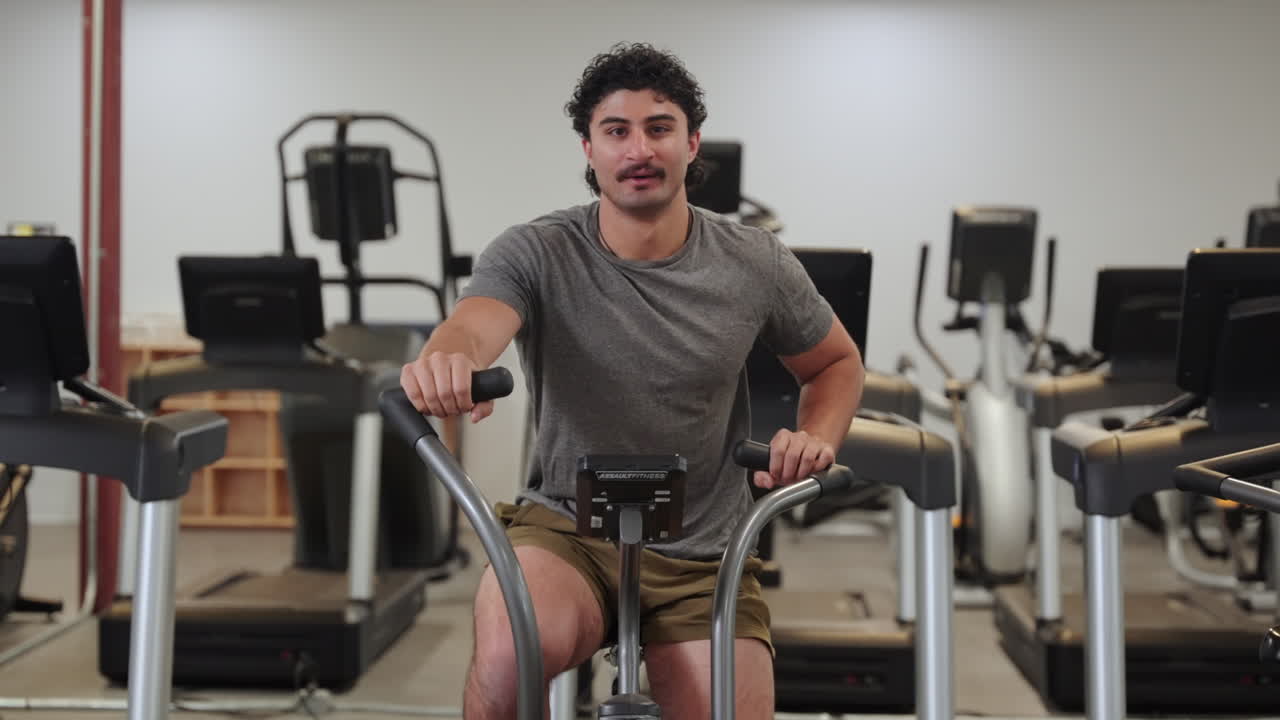 Man doing endurance exercise on stationary bike in the gym