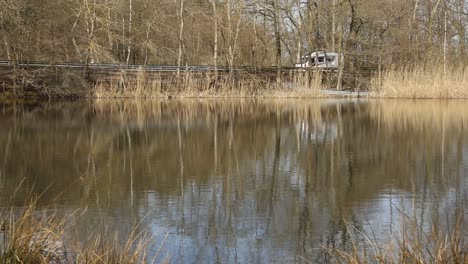 A-Camper-is-driving-infront-of-a-sea-in-rural-Germany