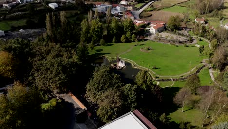 aerial view of a park in paços de ferreira portugal surrounded by trees, fields, and buildings