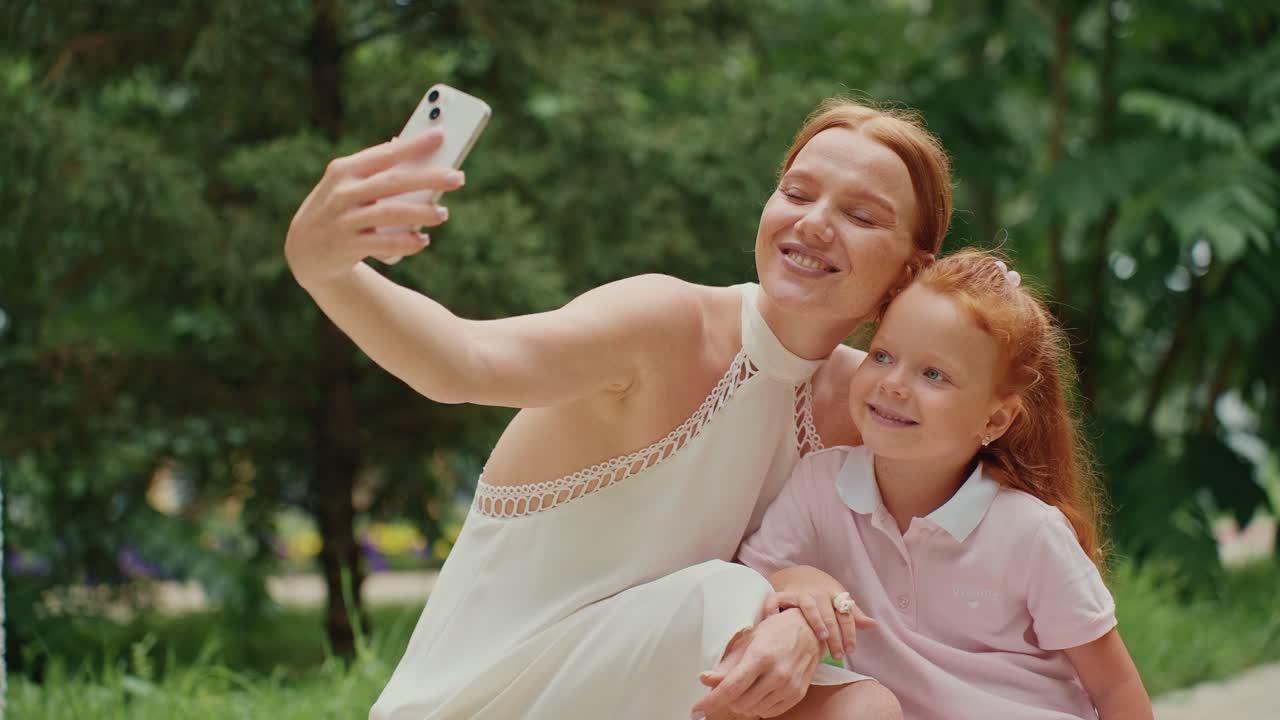Mother and Daughter Taking a Selfie in a Park