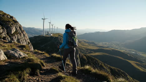 woman hiking in the mountains with wind turbines in the background