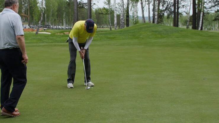 Uomo che imbuca su un campo da golf