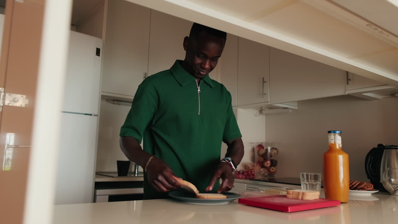 Young African Man Preparing Toast for Breakfast in Kitchen
