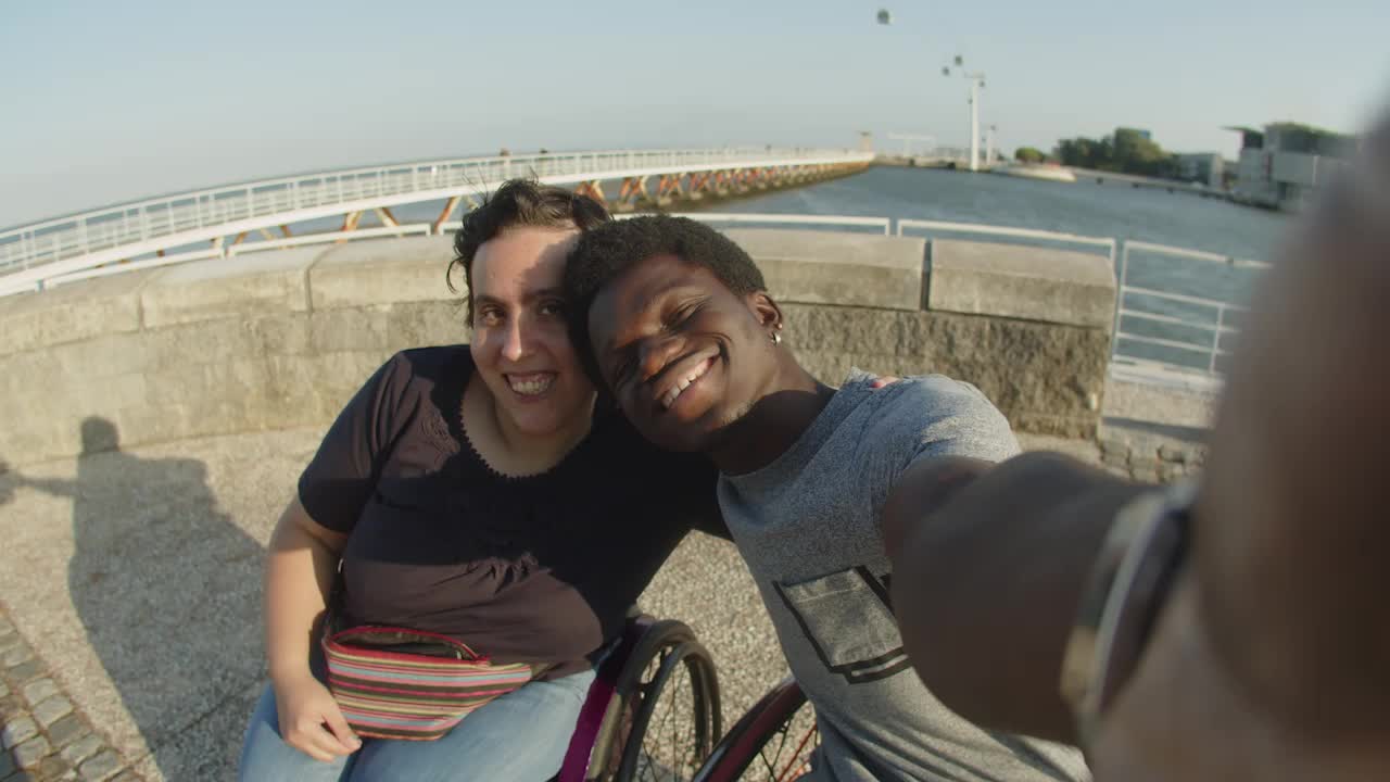 Casal feliz em cadeiras de rodas tirando selfie ou gravando vídeo