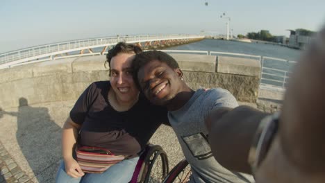 Happy-couple-using-wheelchairs-taking-selfie-or-video