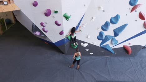 mujeres escalando la pared de rocas con mangos coloridos