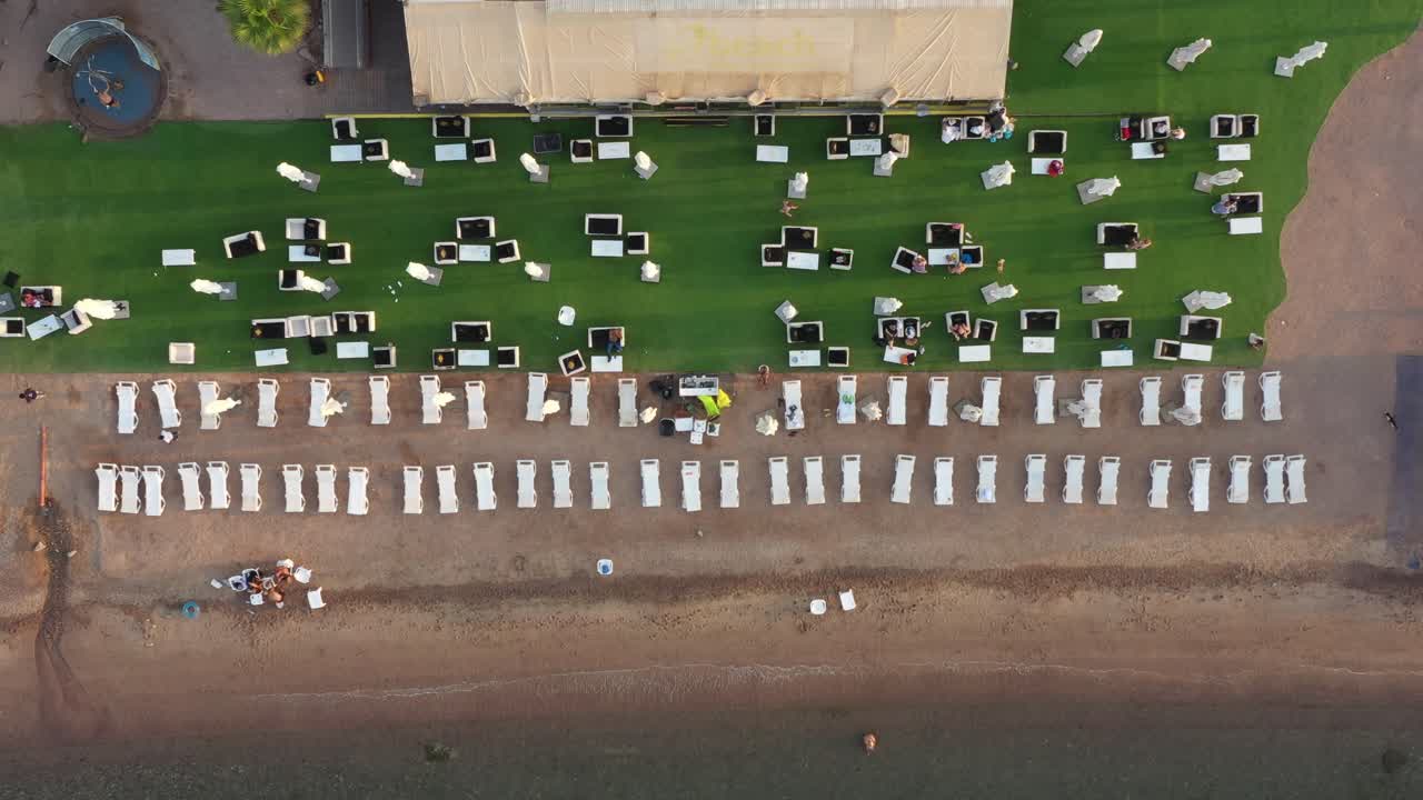 해변 침대가 있는 빈 해변, 수중 산호가 있는 사막의 그늘, 홍해, 에일랏, 이스라엘 공중에서 수영하는 사람들을 위한 부두