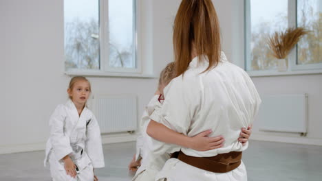 alumno y maestro en kimono blanco en la clase de artes marciales