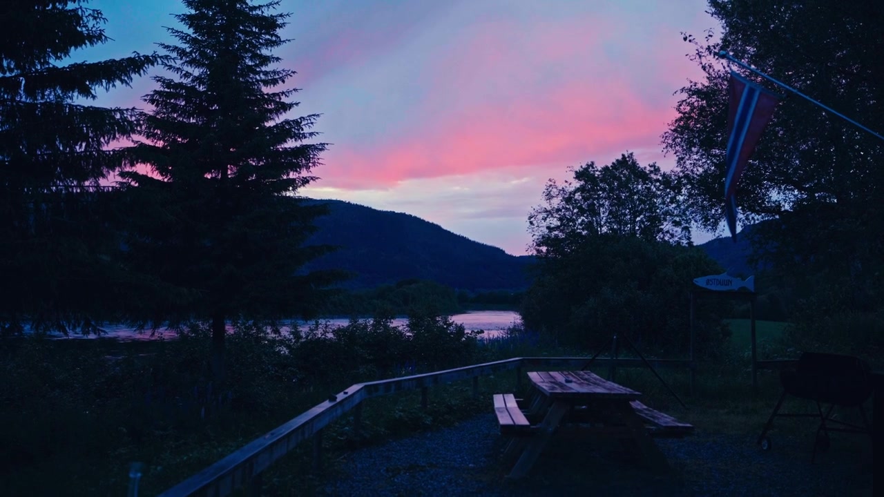 Un tavolo da picnic si trova lungo il fiume Namsen al tramonto, nel Trøndelag, Norvegia - Ripresa a mano libera