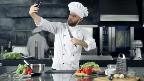 male chef taking selfie photo at kitchen. professional chef with knife