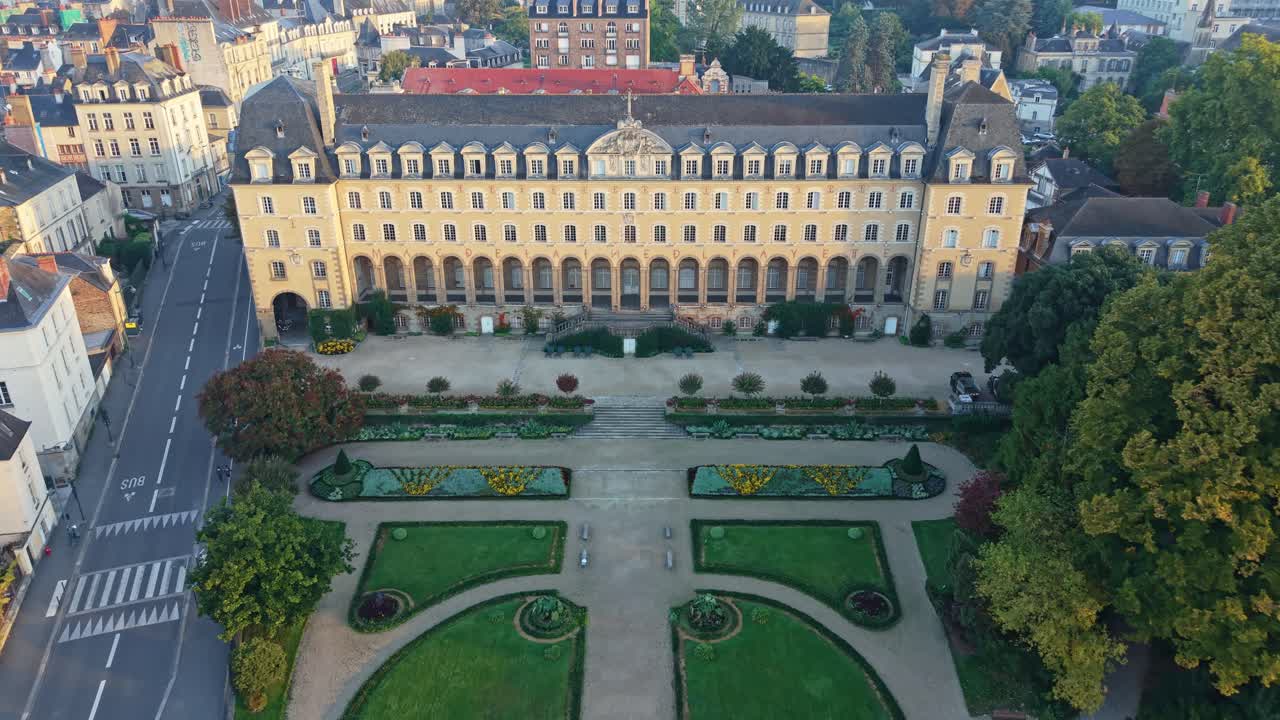 Drone retreating above Palais Saint-Georges in Rennes, France revealing the formal gardens at sunrise