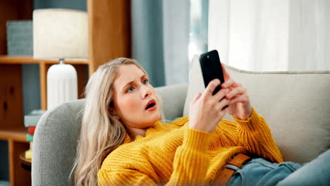 woman looking at phone on couch
