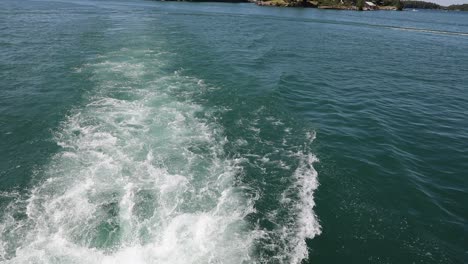 a motorboat sails on a lake with blue water and a jet ski passes in the background