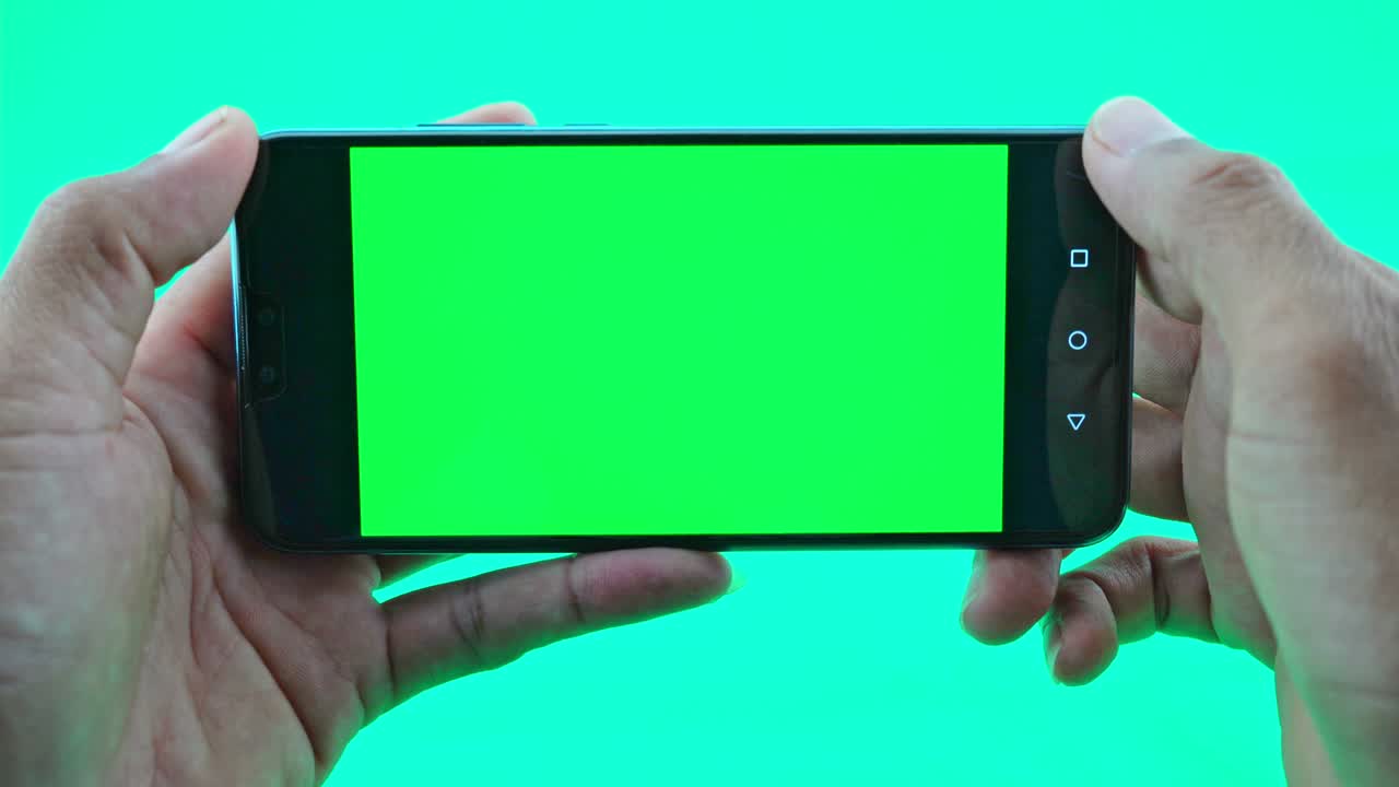 녹색 화면 배경 에 스마트폰 이나 드폰 을 들고 있는 사람 의 손