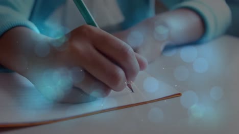 animación de bokeh sobre las manos de un niño caucásico escribiendo en la escuela