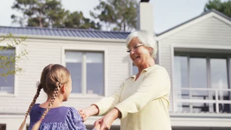 Grandmother-and-little-girl-hugging-while-dancing-happily-4K-4k