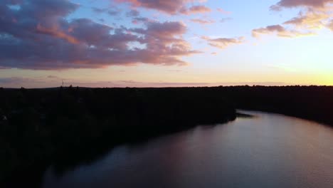 Denso-Bosque-Caducifolio-Alemán-Junto-Al-Lago-Hermosa-Vista-Aérea-Vuelo-Boom-Slider-Drone-Imágenes-Del-Lago-Schlachtensee-Berlín,-Dorado-Atardecer-De-Verano-2022