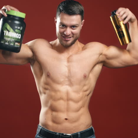 shirtless bodybuilder with bottles. handsome guy with perfect muscular torso recommending nutritional supplements. proteins for sportsmen.