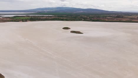 aerial view of a vast saltwater lagoon in sardinia, italy. surrounded by wild nature, this serene wetland is a haven for birdwatching and natural beauty, ideal for nature footage.