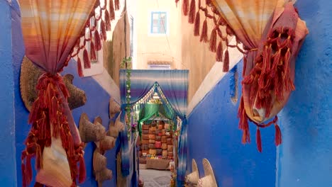 walking down colorful alleyway towards market in chaouen , morocco