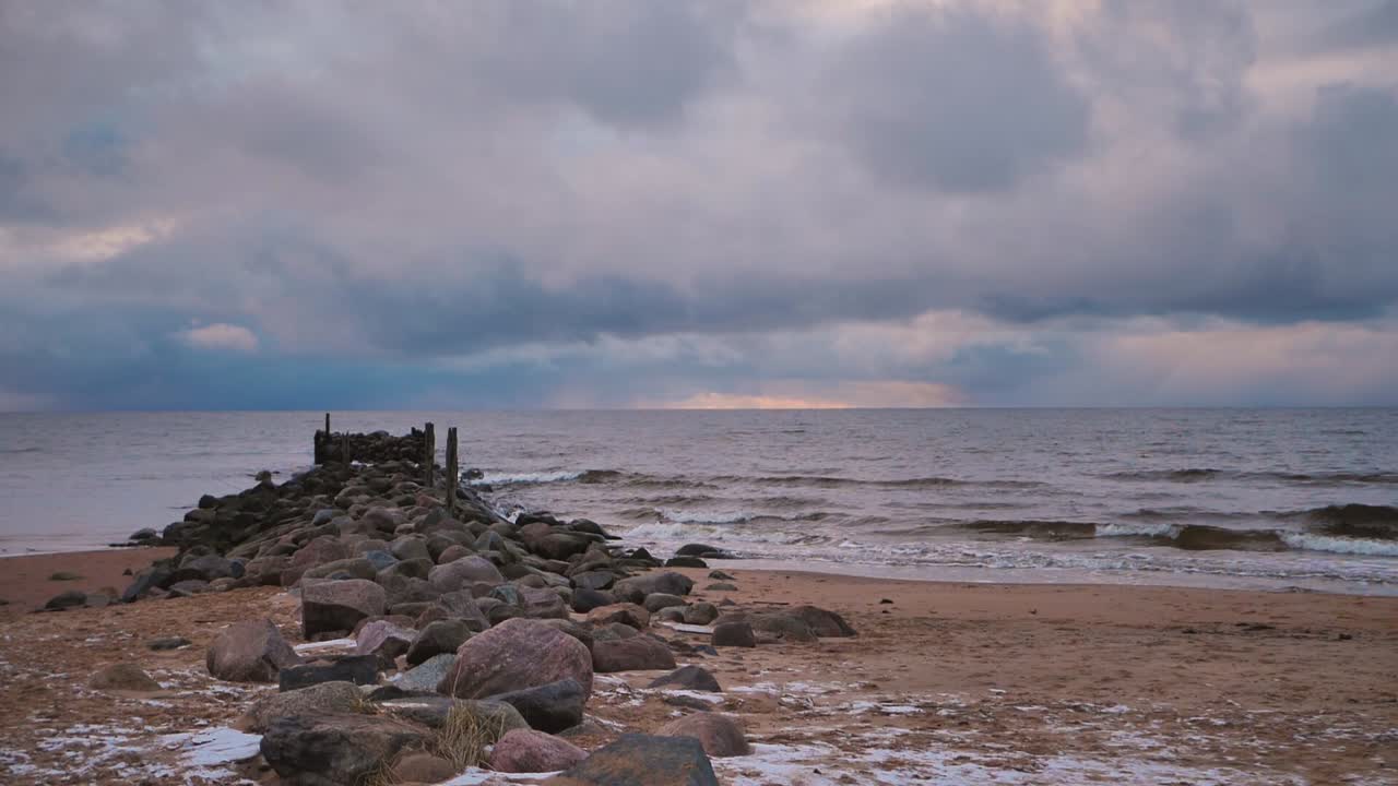 морская волна смывает старый заброшенный каменный пирс