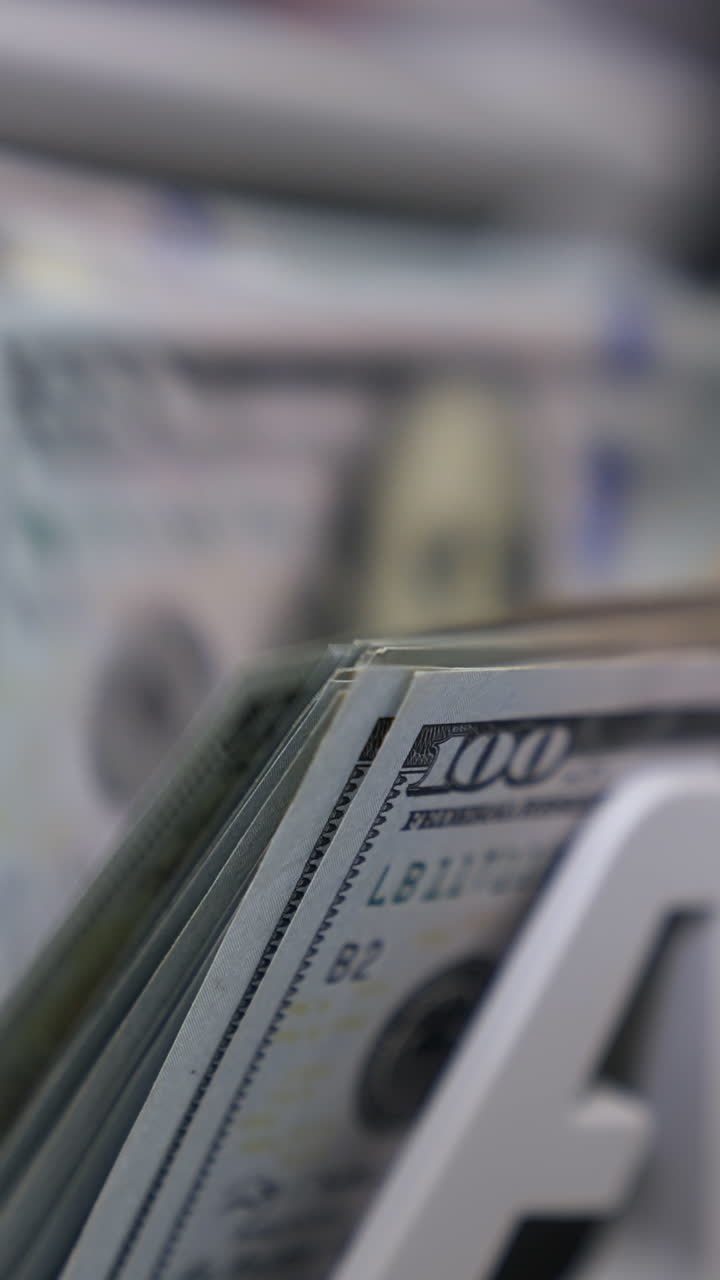 Close Up money counting machine. A bunch of american Banknotes. The world currency is the US dollar. Vertical video