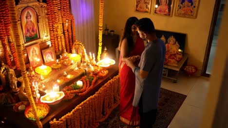 couple praying at a hindu home altar