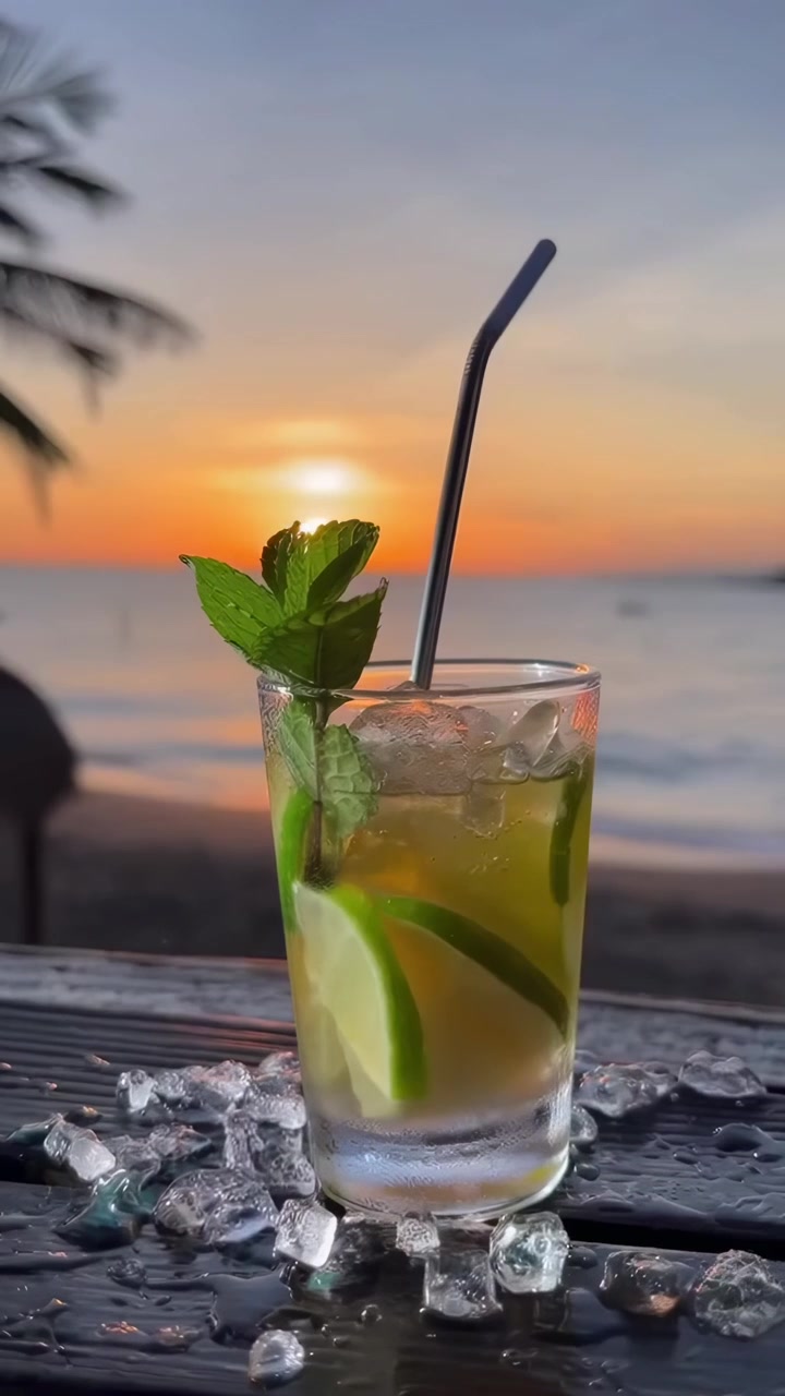 Cocktail Mojito rinfrescante su un tavolo da spiaggia al tramonto
