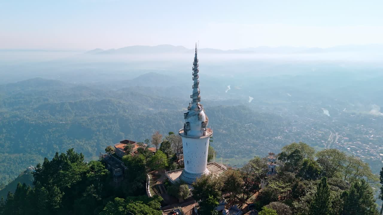 Experience the grandeur of Ambuluwawa Tower close to Kandy city at sunrise, captured from a drone.