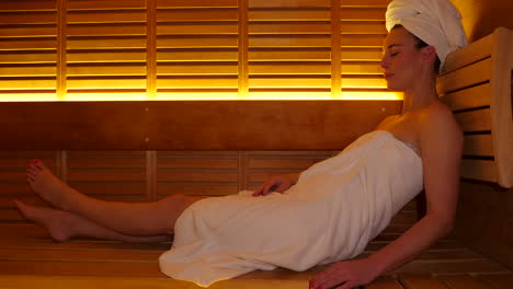 attractive adult caucasian woman laying in modern finnish sauna