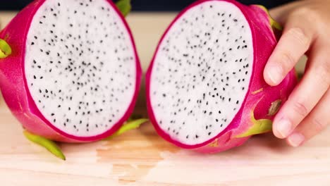 hands examining and holding dragon fruit halves