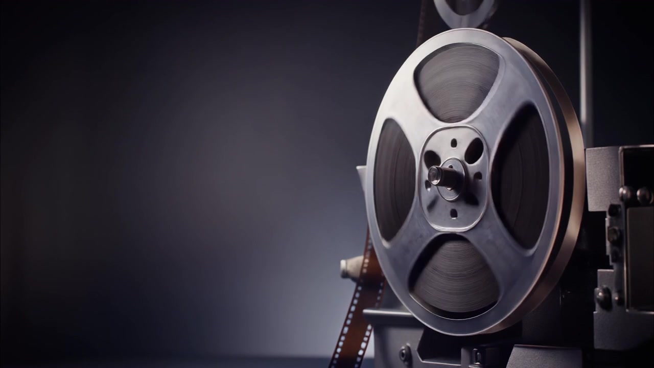 Bobina di proiettore cinematografico vintage che gira in una stanza buia.