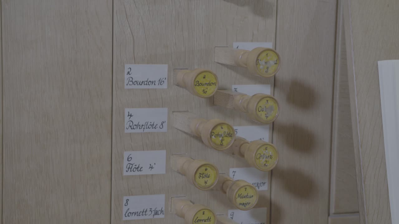 Camera panning along the stops of a wooden organ
