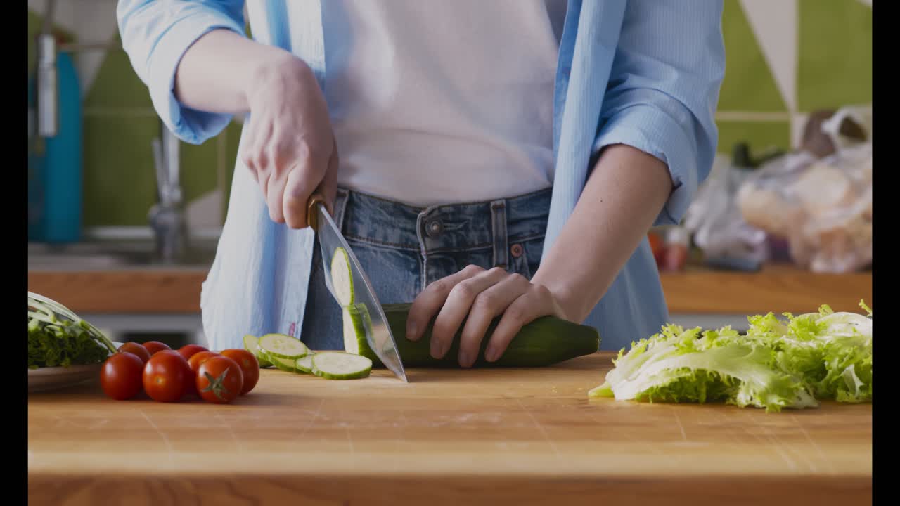mujer cortando pepino en una cocina
