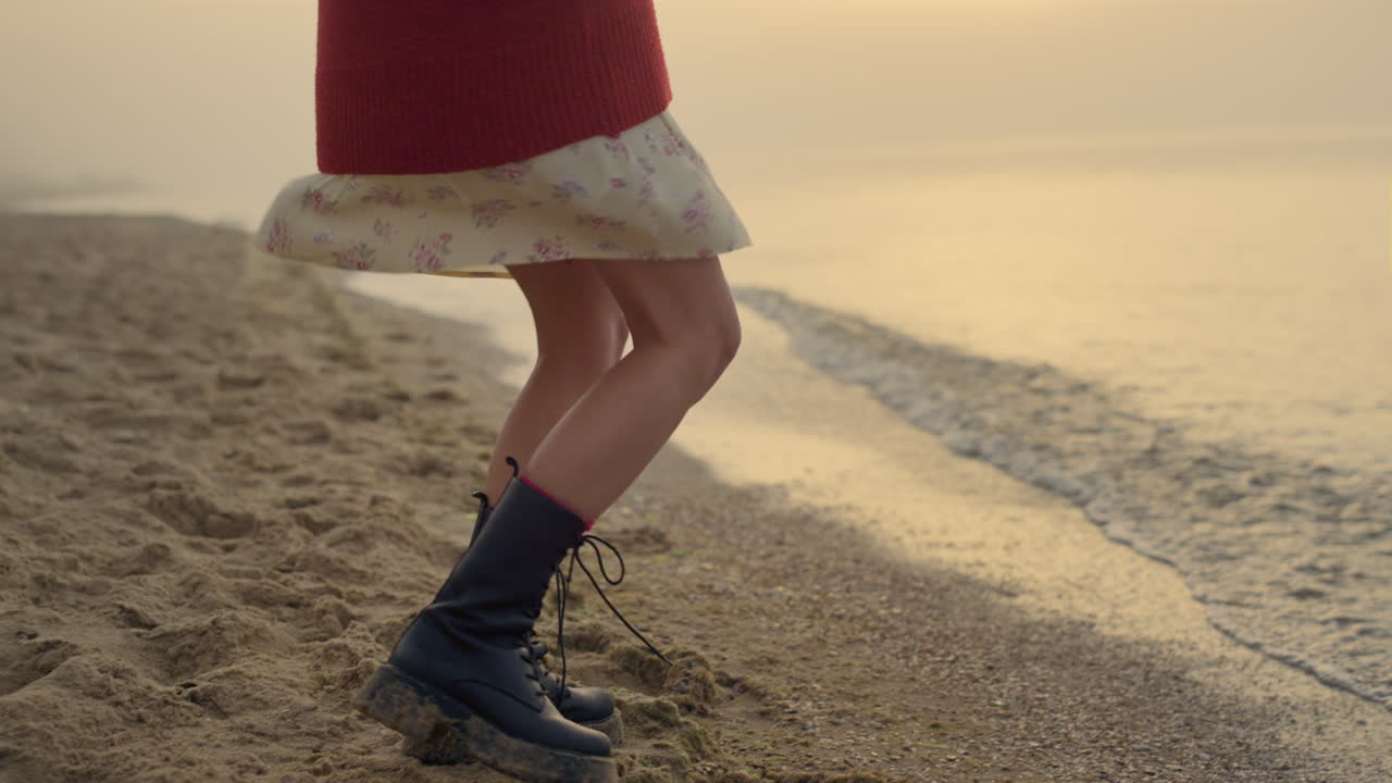 piernas de mujer activas bailando en la playa. chica casual en botas de moda dando la vuelta